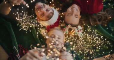 Gülümseyen genç kadınlar ve kafası karışmış parlak ışıkları olan bir adam Noel boyunca evde yatıyorlar.