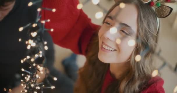Uśmiechnięta Młoda Kobieta Świecącymi Światłami Przez Przyjaciela Czasie Świąt Bożego — Wideo stockowe