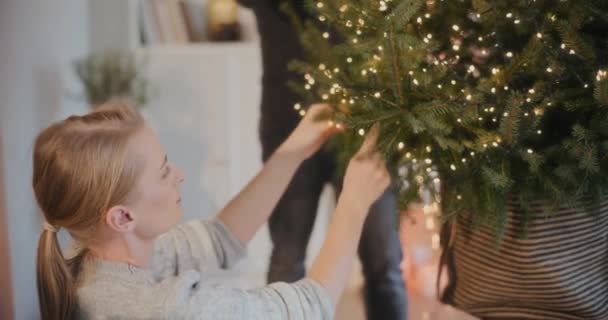Junge Frau Schmückt Weihnachtsbaum Von Freund Hause Urlaub — Stockvideo
