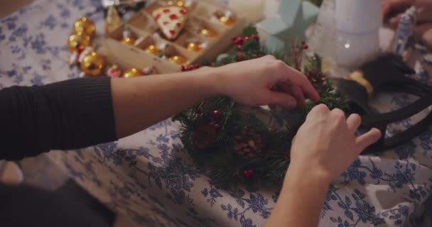 Midsection Man Tying Baubles Wreath Table Living Room Christmas Holiday — Stock Video