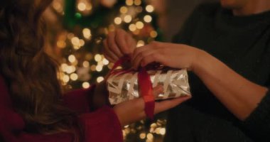 Noel hediyesinde kadın arkadaşının evde tuttuğu kurdele bağlayan adamın orta kısmı.