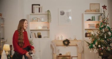 Mutlu heteroseksüel çift Noel tatilinde evde birbirlerine sarılıyorlar.