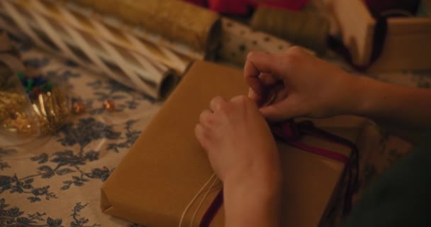 圣诞期间 女人在礼品盒上系带子的剪手 — 图库视频影像