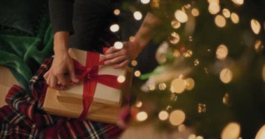 Noel tatili boyunca evde hediye kutularına kurdele bağlayan adamın tam üstünde.