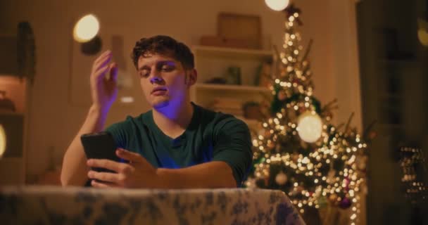 Træt Ung Mand Sms Mobiltelefon Mens Sidder Hjemme Natten – Stock-video