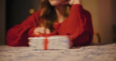 Noel 'de masadaki gülümseyen kız arkadaşa hediye kutusu iten adam.