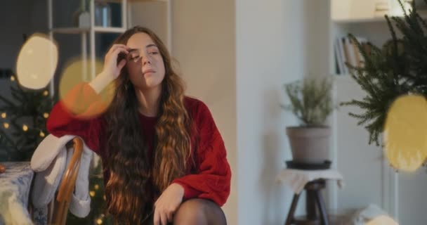 Mujer Joven Preocupada Con Mano Pelo Sentado Casa Durante Navidad — Vídeos de Stock