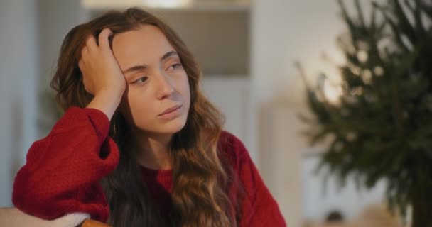Mujer Joven Triste Con Mano Pelo Sentado Casa Durante Navidad — Vídeos de Stock