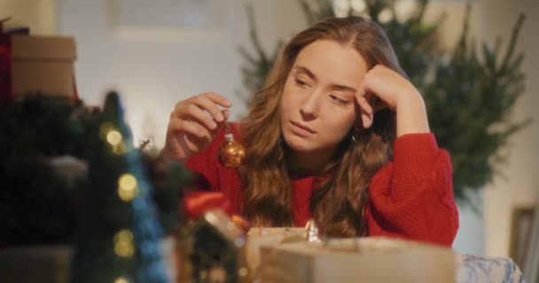 圣诞节期间 头脑清醒的悲哀的年轻女子坐在客厅的桌子旁 — 图库视频影像