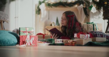 Noel 'de evde yerde yatarken etrafı hediye kitaplarıyla çevrili güzel genç bir kadın.