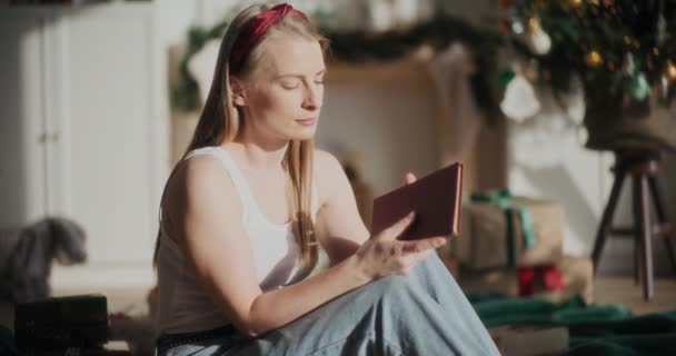 クリスマス中に明るい太陽の光で本を保持しながら目を閉じたリラックスした美しい女性 — ストック動画
