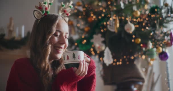 圣诞期间 在家里 头戴驯鹿发带的快乐漂亮的女人闻到了新鲜咖啡的味道 — 图库视频影像