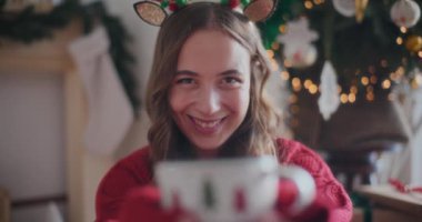 Evde Noel boyunca taze aromatik kahve koklarken gülümseyen güzel genç bir kadının portresi.