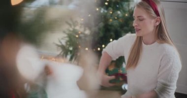 Güzel genç kız kardeşler Noel hediyelerini alırken birbirlerini selamlıyorlar.