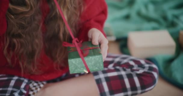 Красивая Молодая Женщина Улыбается Открывая Ленту Обернутый Рождественский Подарок Дома — стоковое видео