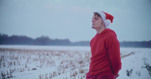 Nachdenklicher Junger Mann Roter Kapuzenjacke Und Weihnachtsmütze Der Weihnachten Auf — Stockvideo