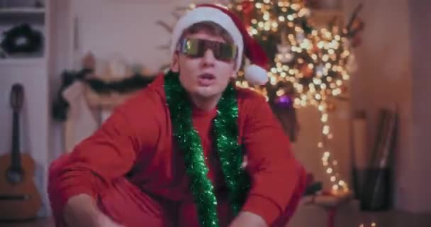 Heyecanlı Genç Adam Boynundaki Yeşil Süslemelerle Noel Boyunca Aydınlatılmış Evde — Stok video