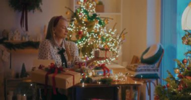 Evdeki Noel ağacının yanında oturan kadın.