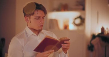 Noel 'de evde otururken kitap okuyan yakışıklı genç adam.