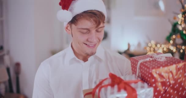 Ritratto Bel Giovane Cappello Babbo Natale Sorridente Mentre Guarda Regali — Video Stock