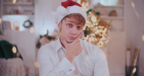 Retrato Jovem Confiante Com Mão Queixo Usando Chapéu Papai Noel — Vídeo de Stock
