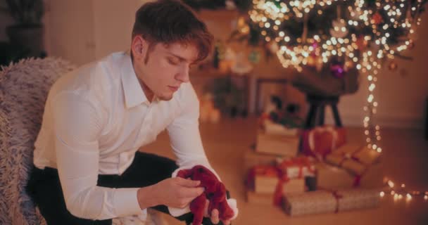 Depressed Young Man Sitting Head Hands Chair Home Illuminated Christmas — Stock Video