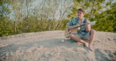 Olumlu gitarist elinde gitar tutuyor açık havada gitar çalıyor dans ediyor ve yürüyor.