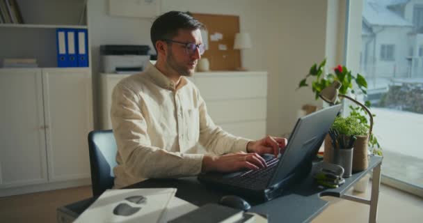 年轻的男性商人坐在办公桌前 戴着眼镜 在笔记本电脑上工作 — 图库视频影像