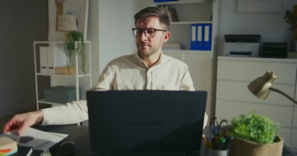 失望的商人坐在办公桌前审查报告和使用笔记本电脑 — 图库视频影像