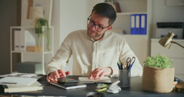 Masada Otururken Ofiste Çalışırken Bütçeyi Hesaplayan Erkek Girişimci Hayal Kırıklığına — Stok video