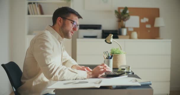 疲惫不堪的男性企业家在办公室工作时编写财务报告的侧貌 — 图库视频影像