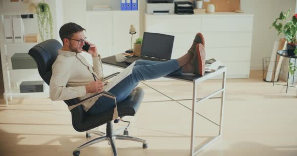 全身上下都是男性商业专业人士 他们坐在办公室的椅子上 一边用智能手机聊天 一边看文件 — 图库视频影像