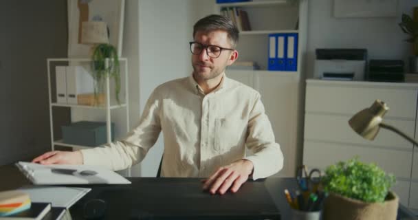 Jovem Empresário Masculino Examinando Relatórios Trabalhando Laptop Enquanto Sentado Mesa — Vídeo de Stock