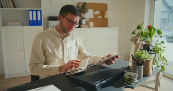 オフィスの机に座っている間 男性起業家の計画戦略とレポートを調べる — ストック動画