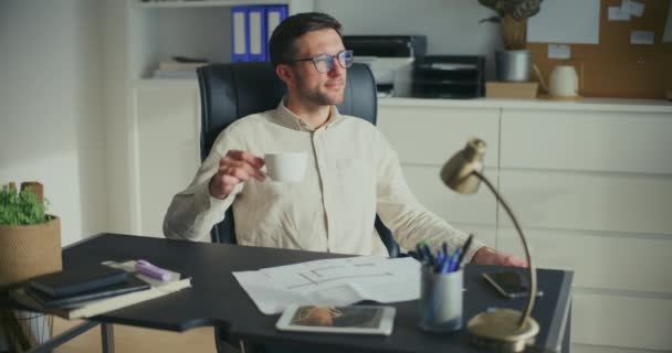 年轻体贴的商人一边喝咖啡 一边在办公室制定策略 — 图库视频影像
