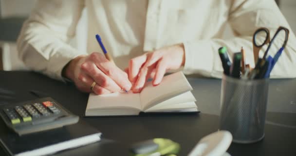 オフィスの机にノートパッドを書いている間 男性起業家の準備戦略のミックス — ストック動画