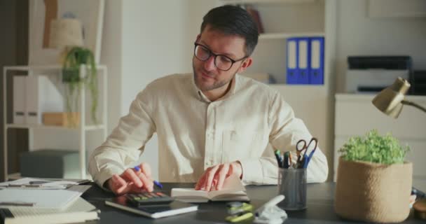 Усміхнений Молодий Бізнесмен Робить Фінансовий Звіт Використовуючи Калькулятор Офісі — стокове відео