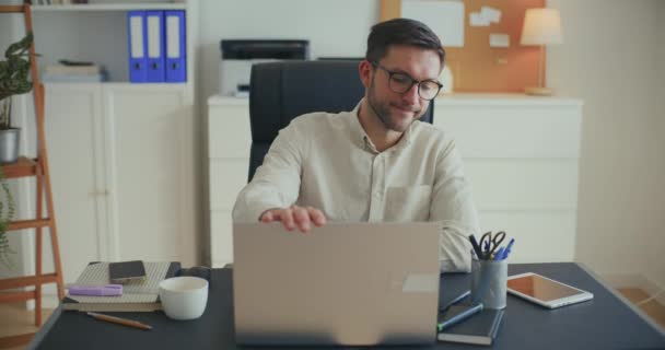 ラップトップを閉じ オフィスの机に座っている間眼鏡を取り除く抑圧されたビジネスマン — ストック動画