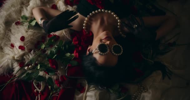 Χαμογελαστή Νεαρή Γυναίκα Μαργαριταρένια Γυαλιά Καλυμμένα Κόκκινα Τριαντάφυλλα Ξαπλωμένη Στο — Αρχείο Βίντεο