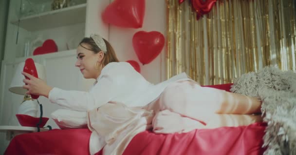 情人节快乐的年轻女子躺在沙发上 一边打电话一边聊天 — 图库视频影像