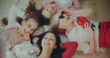 Mutlu moda genç bayan arkadaşlar evde Galentines gününü kutlarken yerde yatıyorlar.