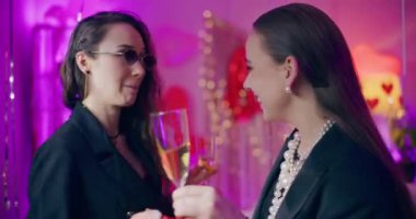 Evde Galentines günü kutlamalarında şampanya içip dans eden kaygısız genç bayan arkadaşlar.