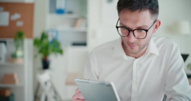 Şirket çalışma sahasında otururken dijital tablette İnternet 'e göz atan kendine güvenen işadamı