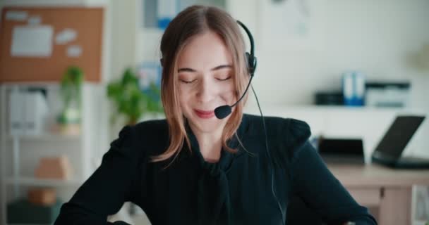 Sonriente Joven Empresaria Hablando Través Auriculares Mientras Está Sentada Oficina — Vídeos de Stock