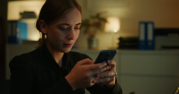 Junge Unternehmerin Scrollt Mit Dem Handy Internet Während Sie Spät — Stockvideo