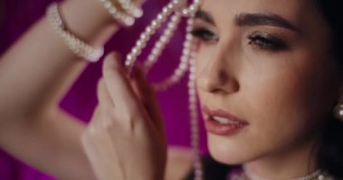 İnci kolyeli baştan çıkarıcı genç bir kadının yakın çekimi.