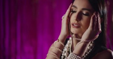 İnci mücevherli, şehvetli ve çekici genç bir kadının yakın çekimi.