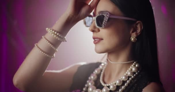 Attraktiv Ung Kvinne Trendy Solbriller Perle Smykker Foran Lys Bakgrunn – stockvideo