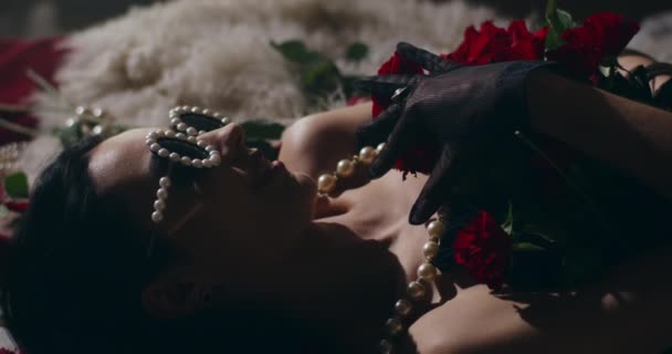 Zbliżenie Uwodzicielskiej Kobiety Perłowych Goglach Pokrytych Różami Leżącej Łóżku — Wideo stockowe