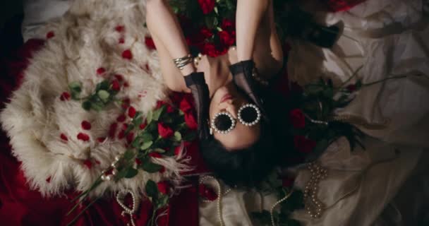 침대에 누워있는 장미로 고글을 착용하는 감각적인 트렌디 — 비디오